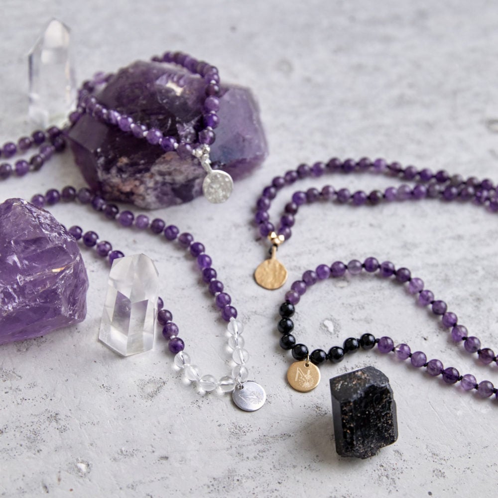 PEACE OF MIND Mala aus Amethyst und Bergkristall Steinen mit silbernen NAIONA Plättchen und Perlen und Mala aus Amethyst und Turmalin Steinen mit goldenen Plättchen und Perlen und Amethyst und Turmalin Steine und Bergkristallspitzen.
